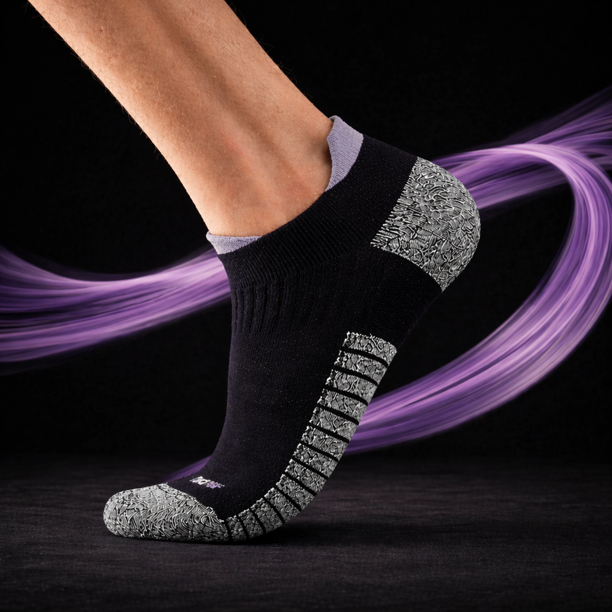 A leg wearing a SHTOOMF climbing sock with purple highlights and a purple swirl around against a black background
